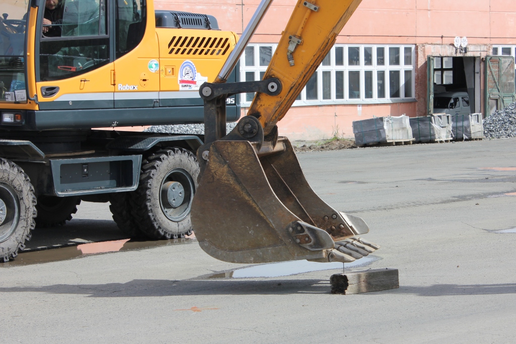 Экскаватор забивает гвоздь